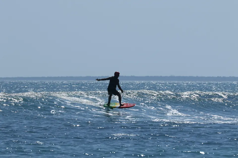 Surfer on a wave at Squealers, Rote Island