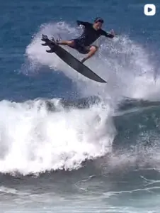 Surfer doing an aerial on a wave in Rote Island